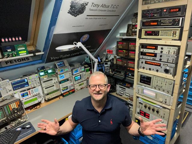 Tony Albus in his electronics workshop surrounded by test equipment